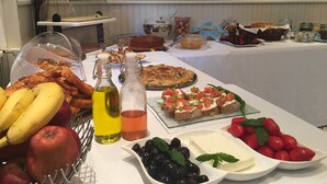 Ein reichhaltiges Buffet mit verschiedenen Speisen, darunter Früchte, Käse und eine Auswahl an Gerichten.