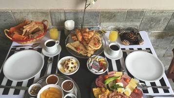 Un buffet de petit-déjeuner avec divers plats, boissons et ustensiles disposés sur une table.