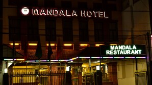 The exterior of the Mandala Hotel with a neon sign and a green sign for the Mandala Restaurant. - Mandala Hotel Pvt.Ltd. (Kathmandu)