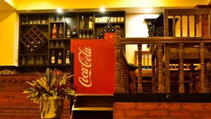 A bar area with shelves of bottles and a Coca-Cola sign. - Mandala Hotel Pvt.Ltd. (Kathmandu)