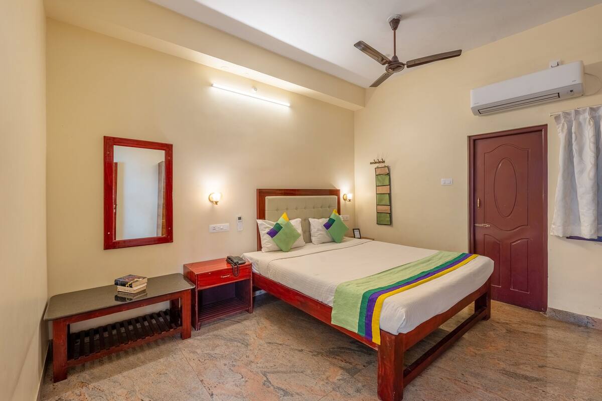 A neatly arranged bedroom with a bed, bedside table, and a bench.