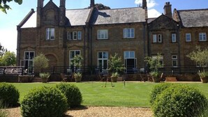 A large, historic stone building with multiple windows and a well-maintained lawn in front. - Lanes Hotel (Yeovil)