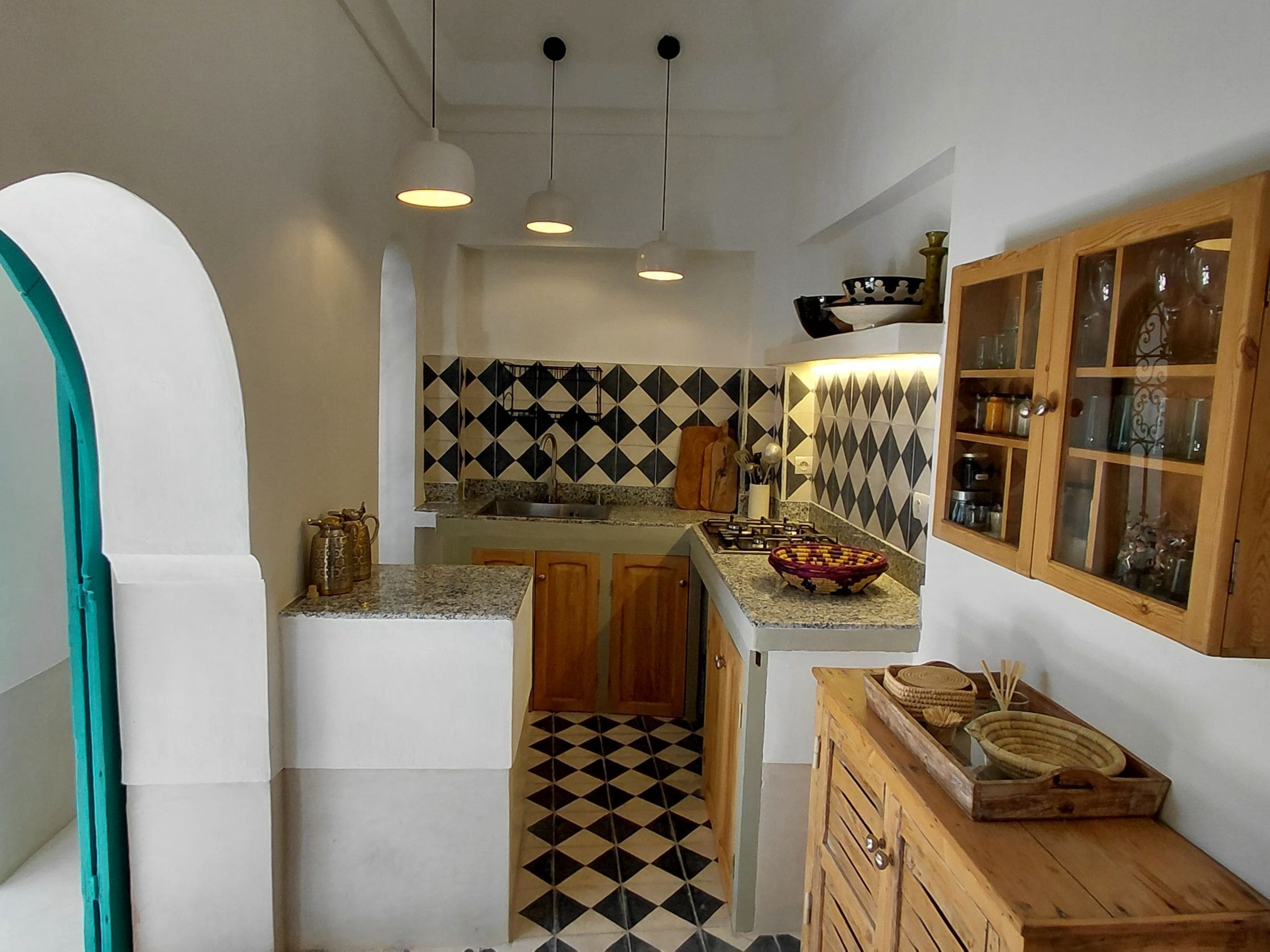 A kitchen with a geometric patterned backsplash, wooden cabinets, and a central island with a woven basket.