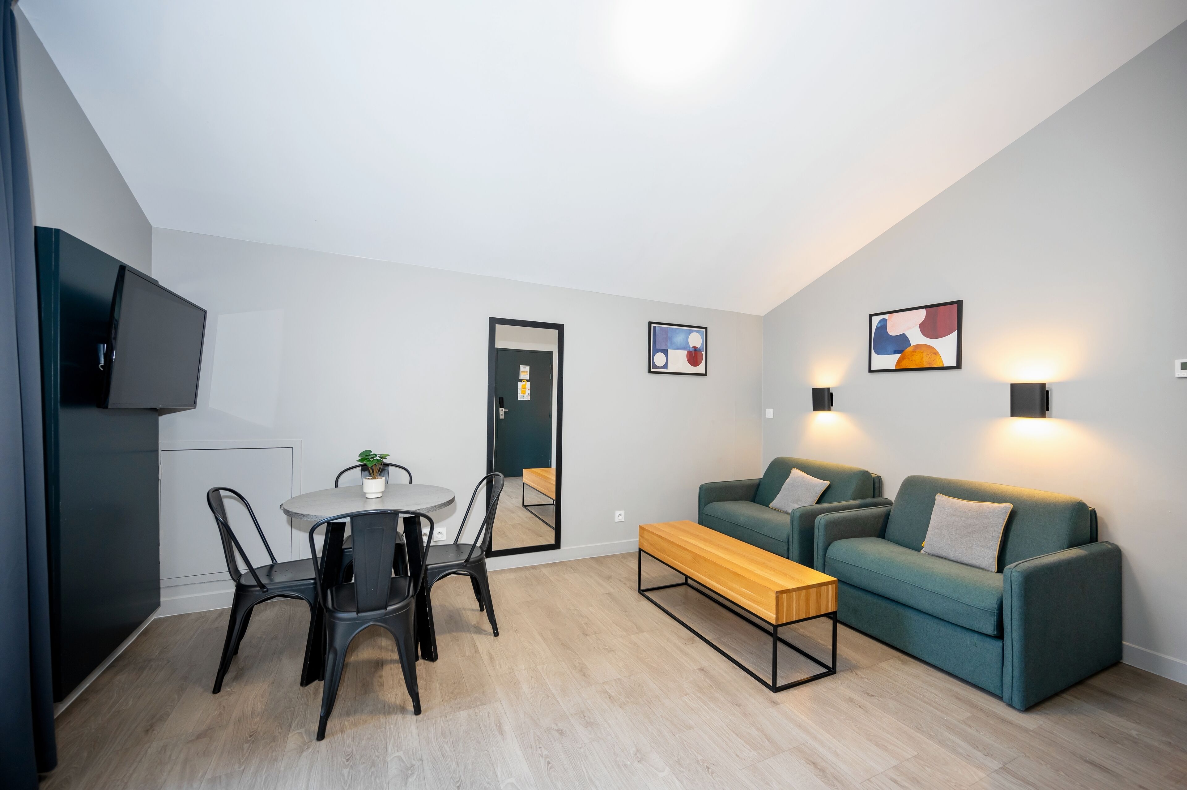 Un salon moderne comprenant un canapé, une table basse et un coin repas avec des chaises et une table.