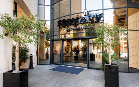 A modern building with a glass facade and the sign "staycity apartments".