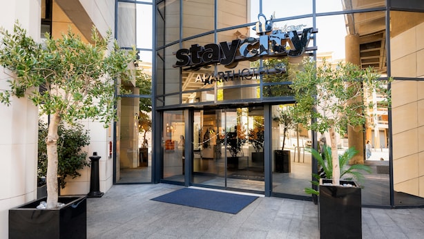 Un immeuble moderne avec une façade en verre et l’enseigne « staycity apartments ».
