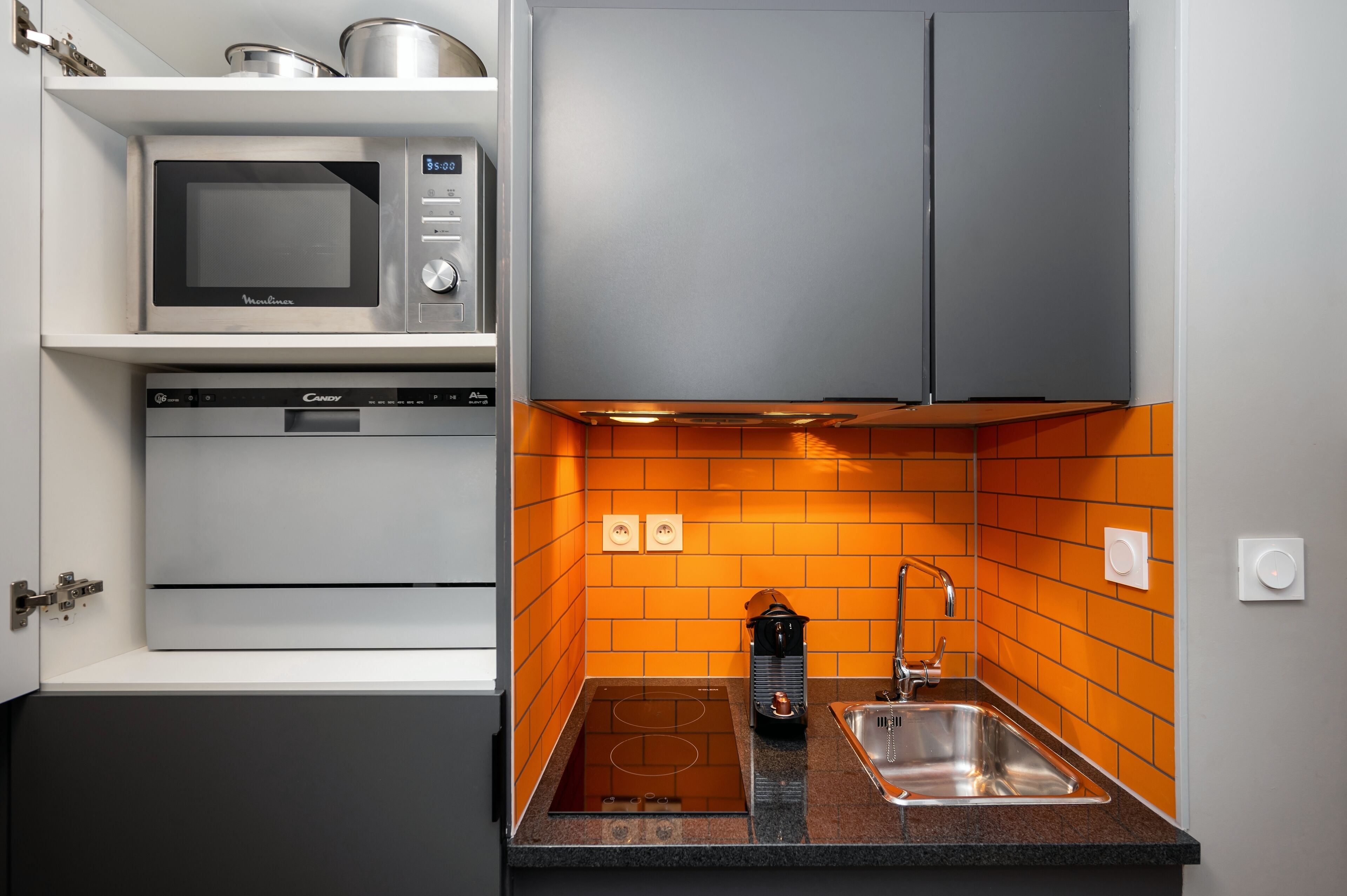 Una cocina compacta equipada con microondas, horno y lavaplatos.