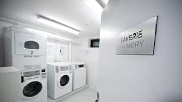 Una sala amb bugaderia, amb un cartell que diu "LAVERIE LAUNDRY" i dues rentadores.