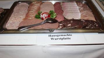 A display of various types of wurst (sausages) with a spoon on top.