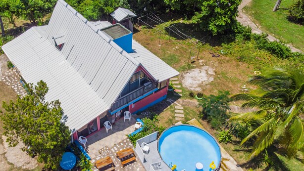 An aerial view of a house with a swimming pool, a covered patio, and a small deck area. - Beautiful View Lodging (San Andrés)