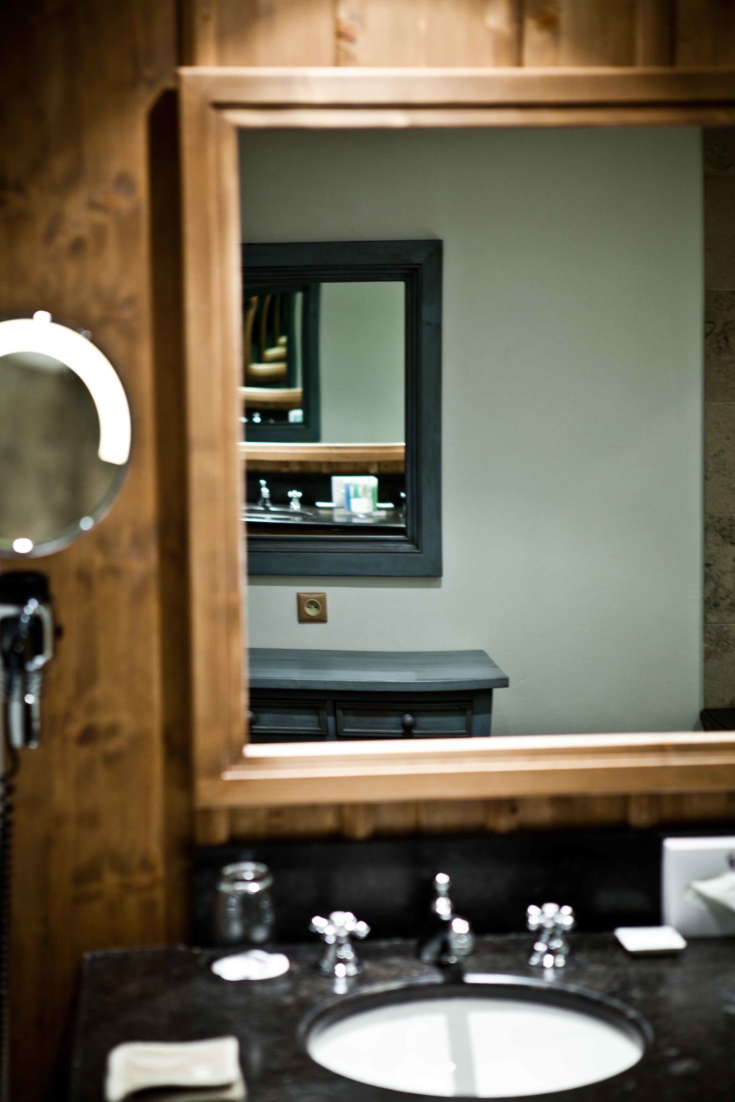 Un bagno con un mobile lavabo in legno, uno specchio e un lavandino.