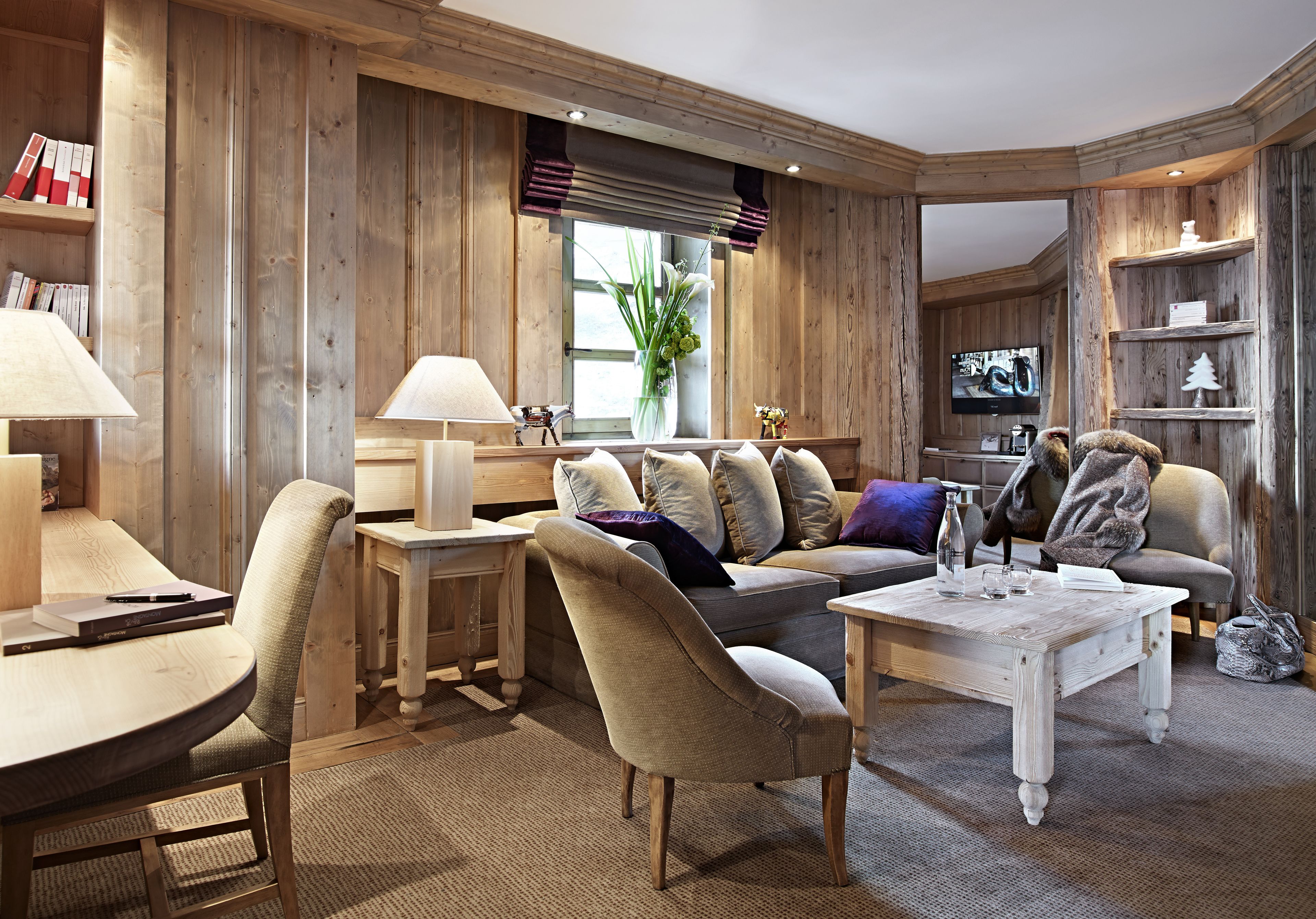 Un salon chaleureux avec un décor intérieur en bois, un canapé, une table basse et un téléviseur.