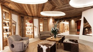 Un ambiente accogliente con rivestimento in legno, un divano, un poggiapiedi e un caminetto.