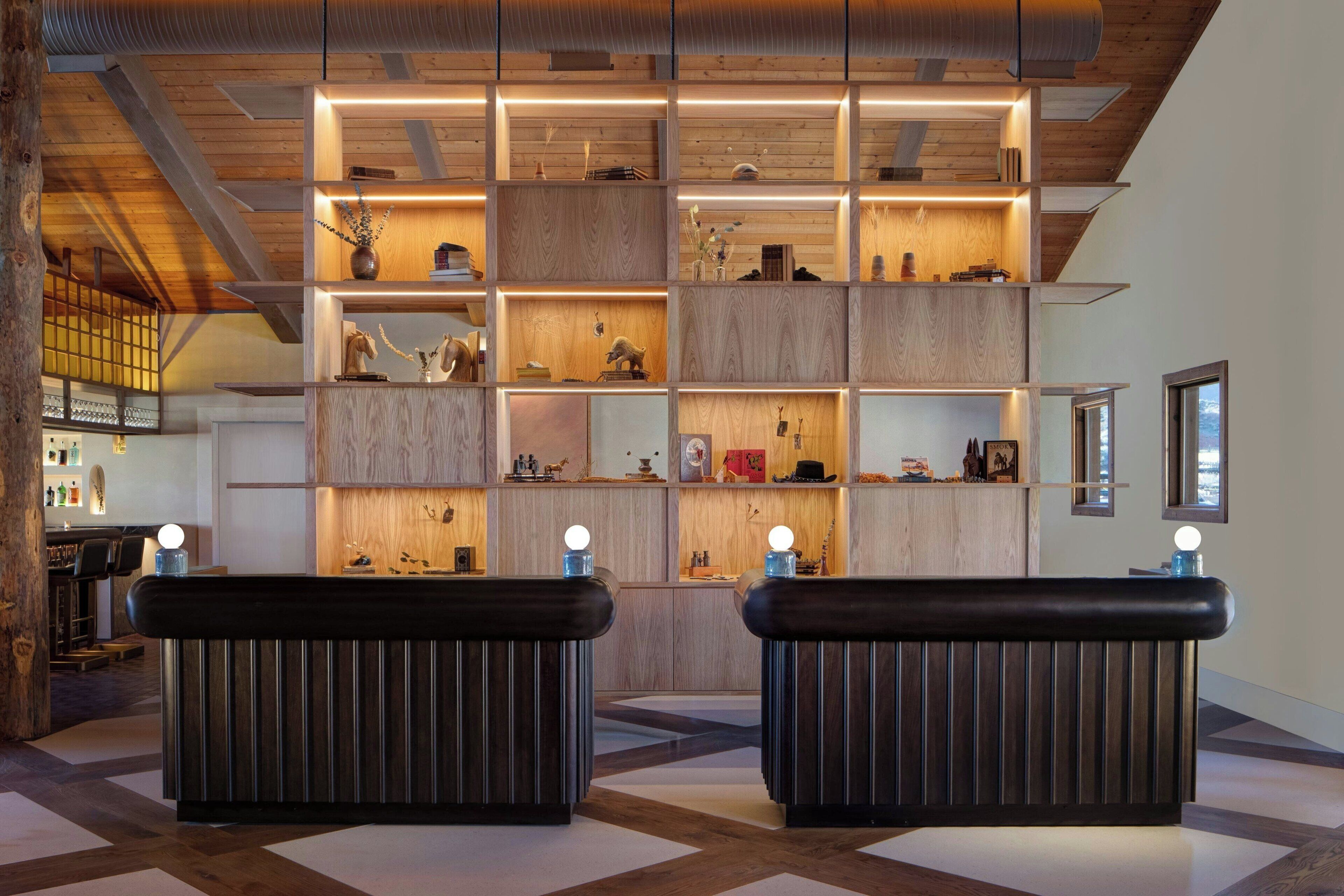 A modern reception area with wooden shelving and a black reception desk.