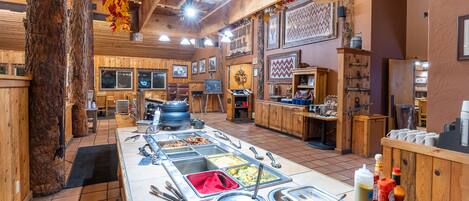 A buffet setup with various food stations and a wooden interior.