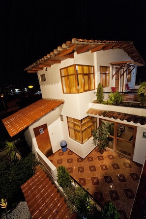 A two-story building with a tiled roof, a balcony, and a small garden area. - El Jacal Classic (Huaraz)