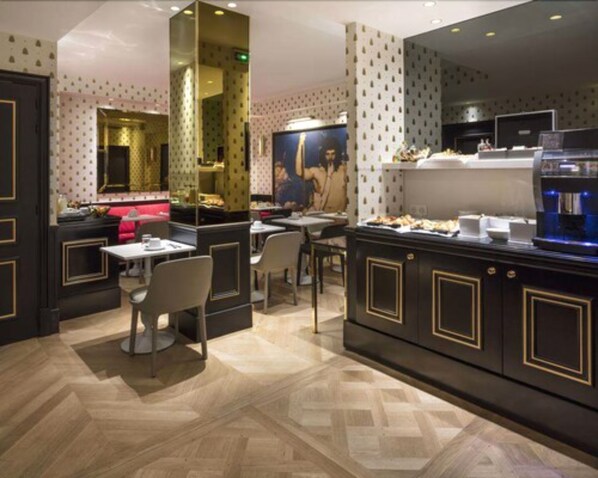 A modern dining area with a central island, seating arrangements, and a large mirror. - Hôtel Eiffel Petit Louvre (Paris)