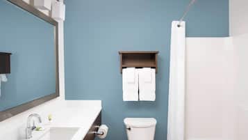 A bathroom with a white sink, a toilet, and a shower curtain.
