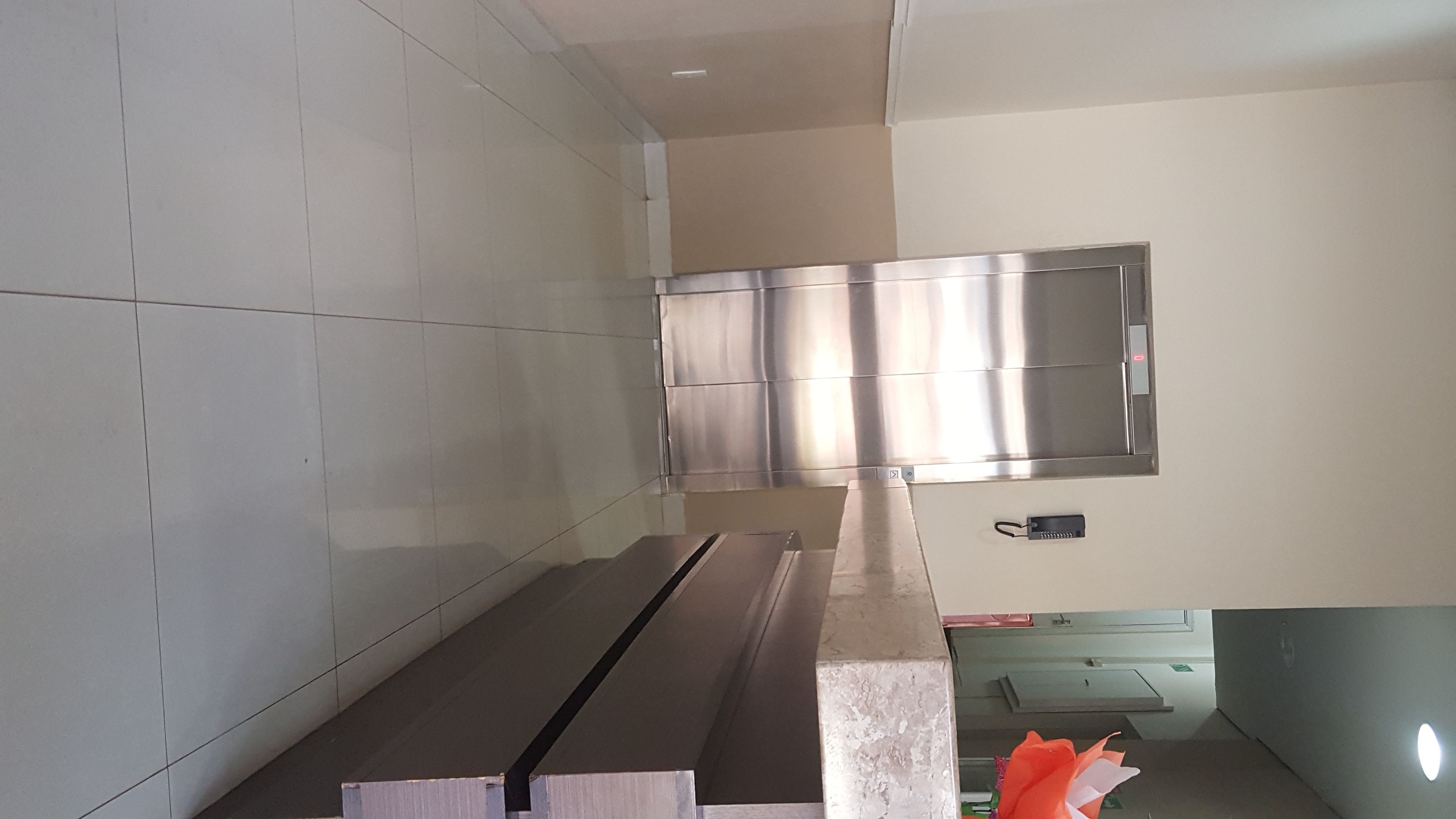 A modern kitchen with stainless steel appliances, a tiled backsplash, and a countertop.