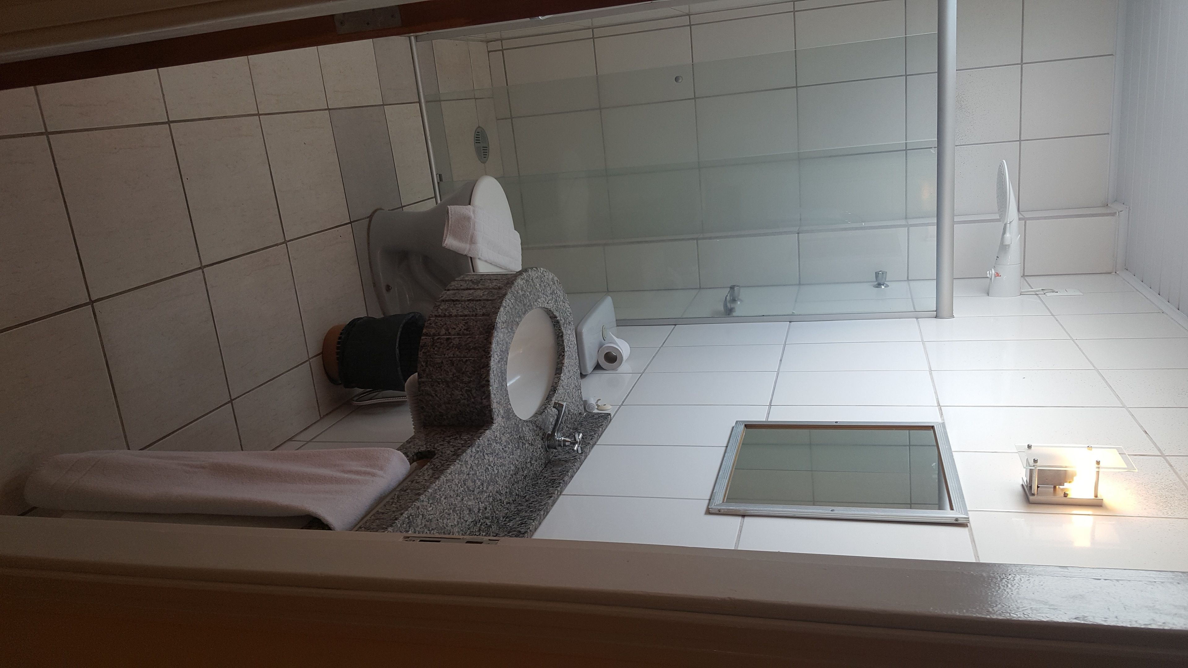 A bathroom with a toilet, sink, and shower.