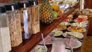 A buffet table with various food items and beverages. - Pousada Villaggio di Roma (Campos do Jordão)