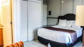 Et hotelværelse med seng, skrivebord, stol og garderobeskab.
