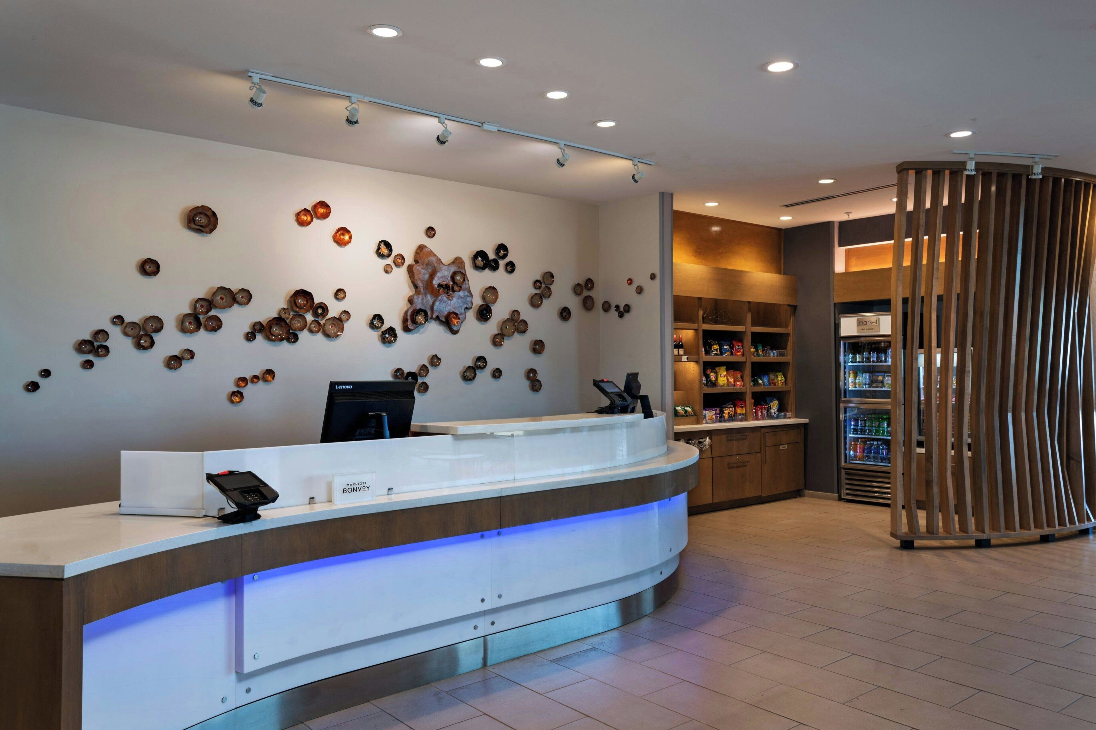 A reception area with a modern counter, a wall-mounted phone, and a decorative wall with circular patterns.