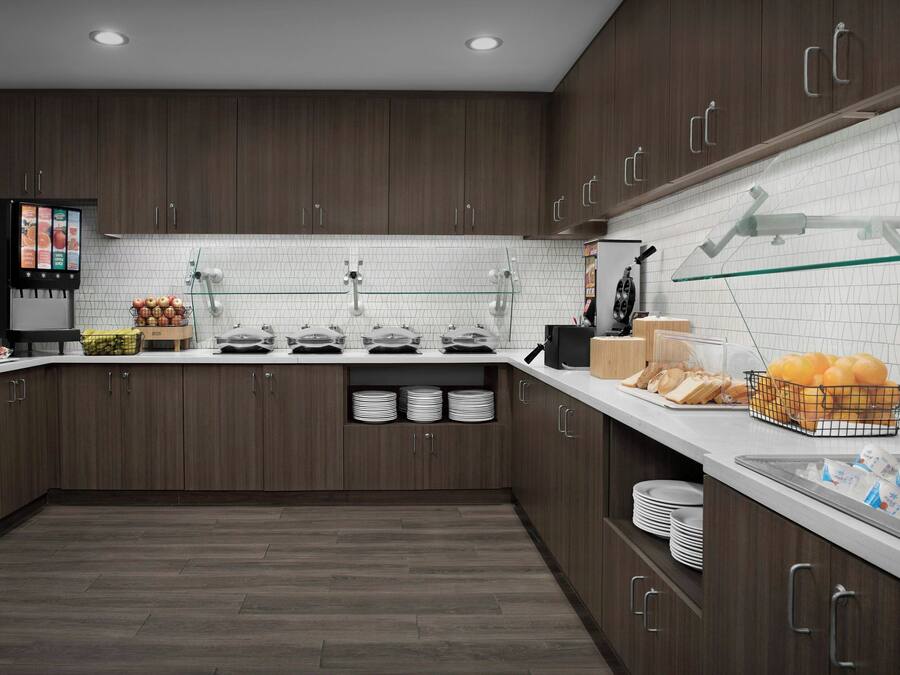 A modern kitchen with dark wood cabinets, a white tiled backsplash, and a glass-fronted display case.