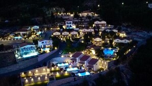 Un resort con múltiples piscinas, conectadas por senderos, rodeado de edificios residenciales.