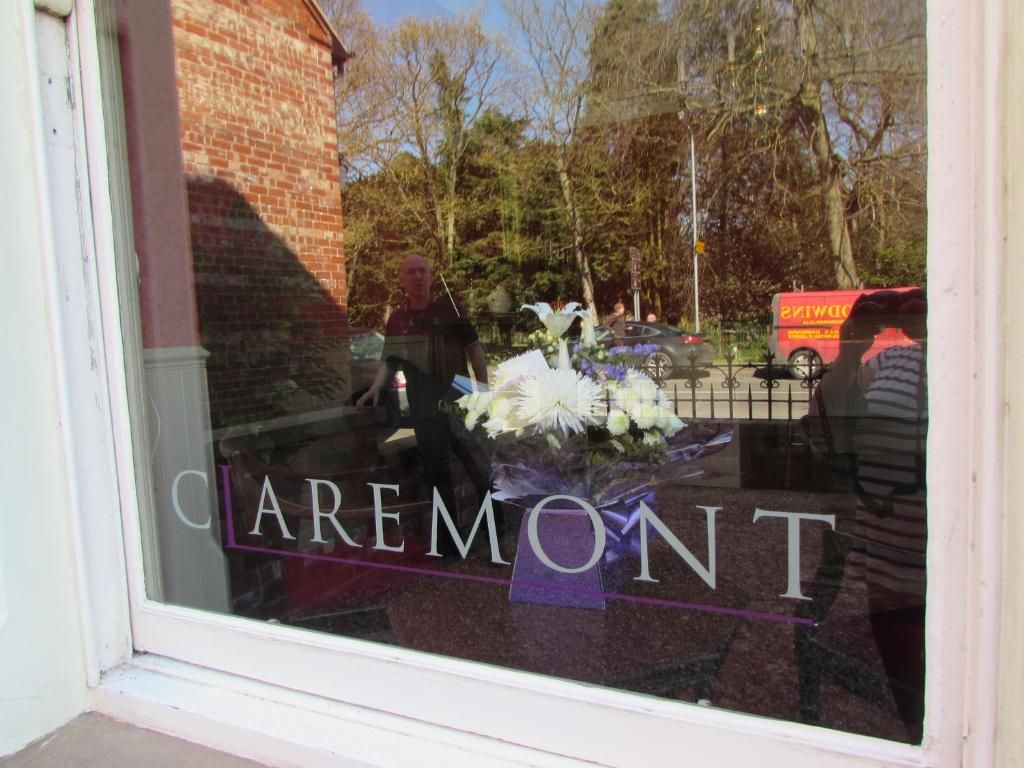 A window with the text 'Caremont' and a bouquet of flowers.