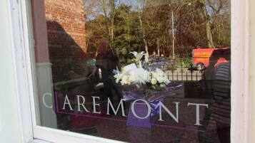 A window with the text 'Caremont' and a bouquet of flowers.