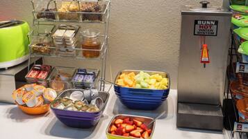 Un'area buffet con diversi cibi e un dispenser di acqua calda.