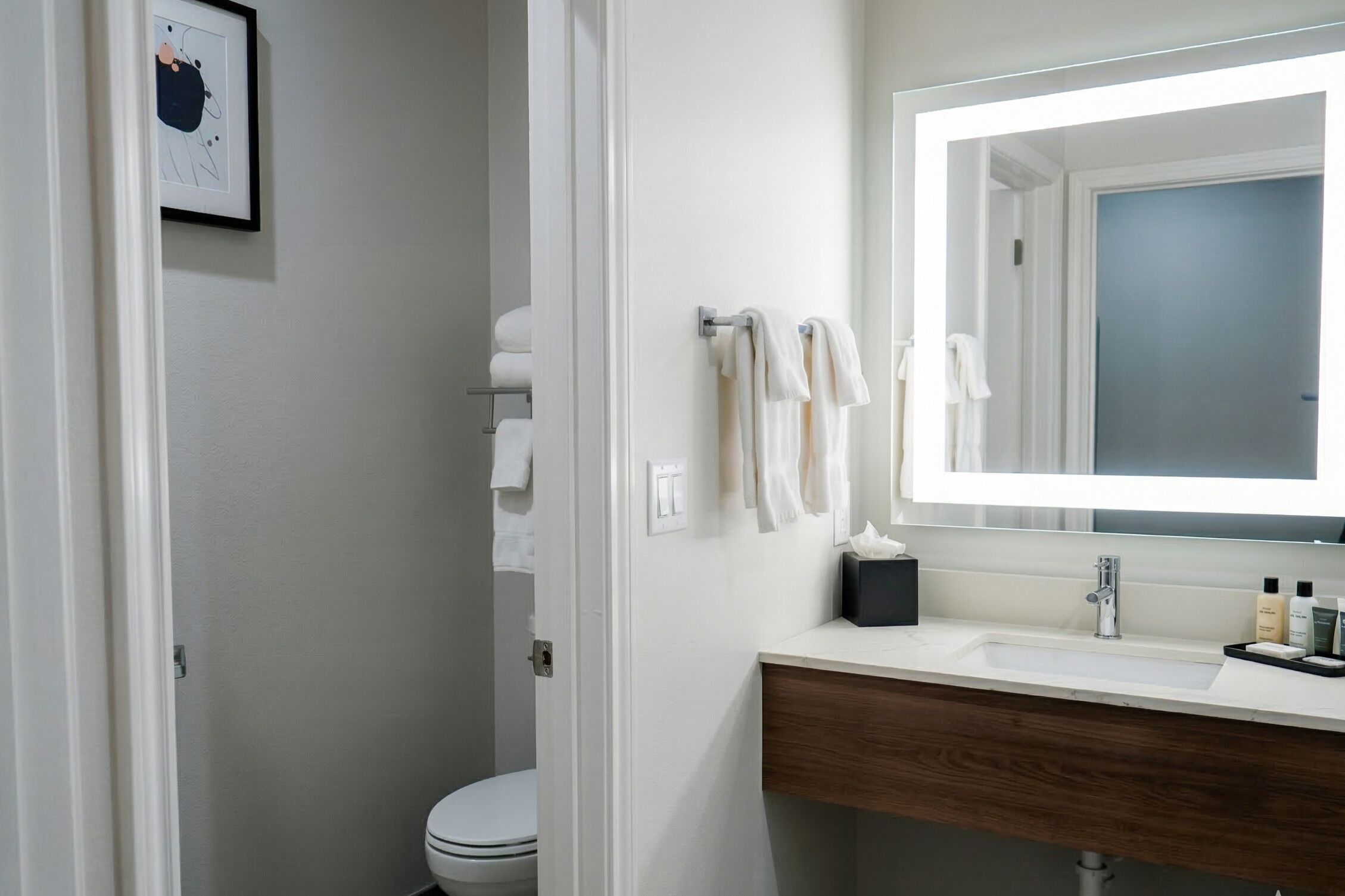 Un baño con un lavamanos blanco, un espejo y un inodoro.