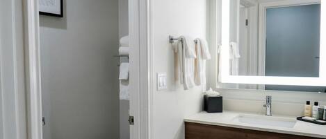 Un baño con un lavamanos blanco, un espejo y un inodoro.