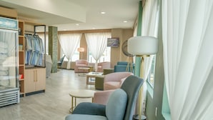 A hotel room with a seating area, a wardrobe, and a television. - Hotel Lydia (Port Aransas)