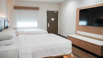 Une chambre d’hôtel avec deux lits, une télévision, une armoire en bois et une porte.