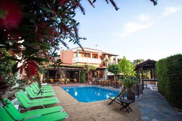 Una piscina al aire libre, sombrillas, tumbonas