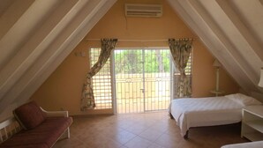 A bedroom with a bed, a chair, a nightstand, and a window with curtains.