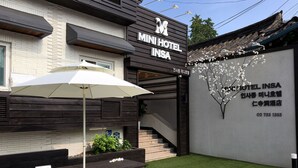Le MiniHotel Insa se distingue par sa façade moderne, son espace extérieur aménagé et un escalier menant à l’entrée.