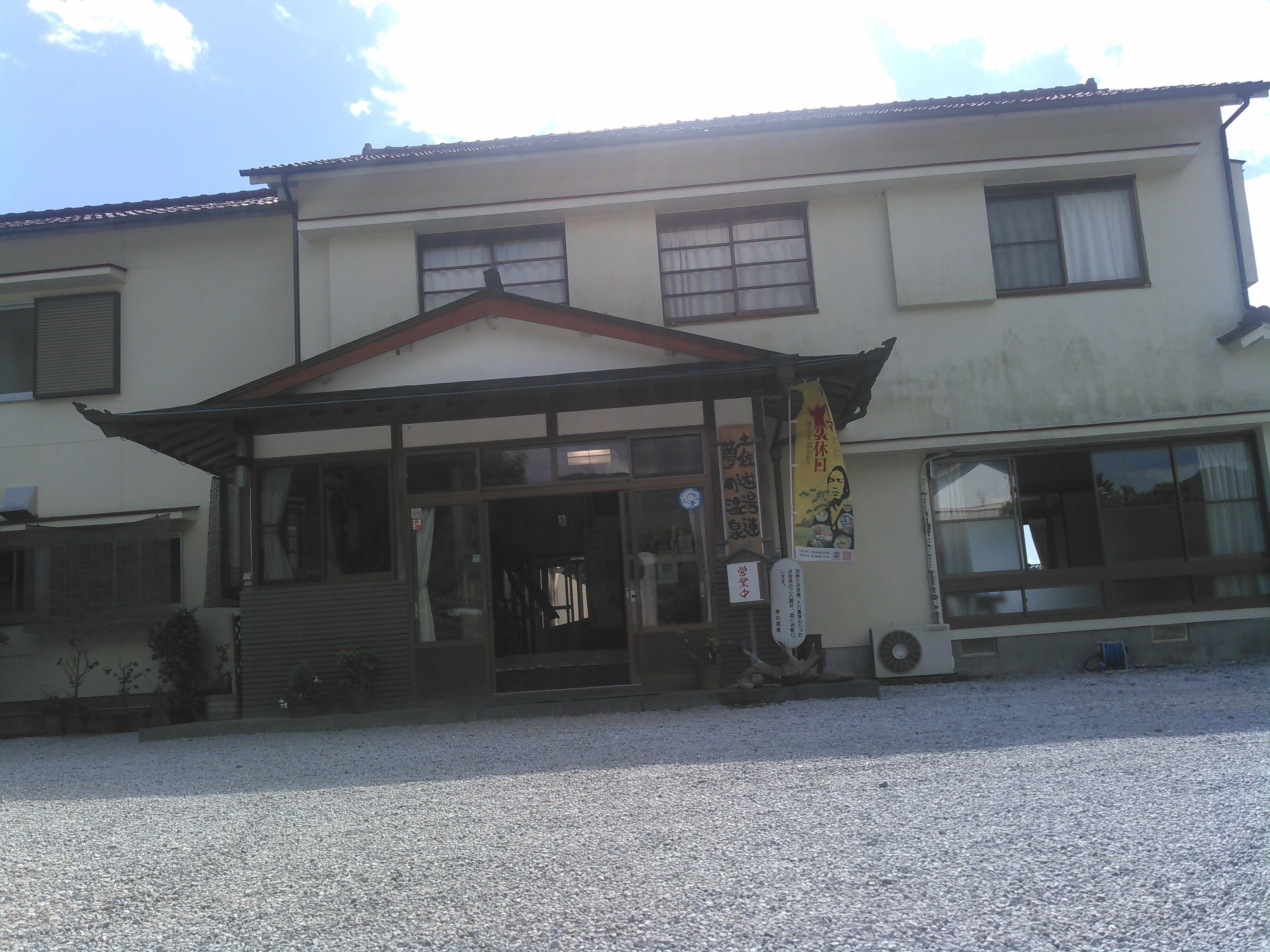 A building with a traditional architectural style, featuring a covered entrance and multiple windows.