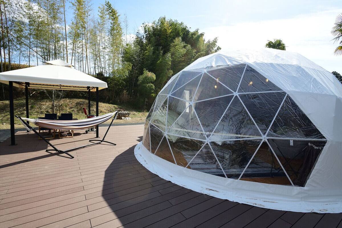 Une structure en forme de dôme géodésique, dotée d’un hamac et d’un espace ombragé.