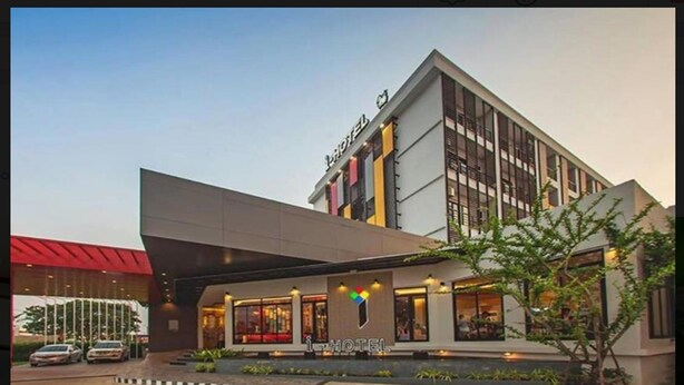 Un hotel moderno con una entrada destacada, ventanas amplias y un logotipo visible.