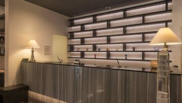 A reception desk with a modern design, featuring a striped pattern and a series of shelves above displaying various decorative items.