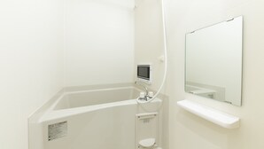 A modern bathroom with a bathtub, a handheld showerhead, a digital control panel, and a mirror. - MUSUBI KYOTO Higashiyama Gojo (Kyoto)