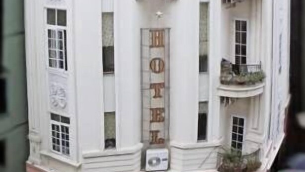 Un edificio blanco de varios pisos con un cartel que dice 'HOTEL' y 'LIGHT' en la fachada.