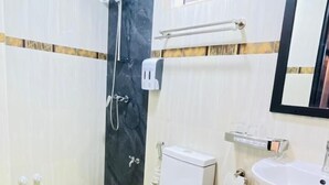 A bathroom with a toilet, bidet, and sink, with a shower area and a mirror above the sink. - Dream Relax (Hulhumalé)