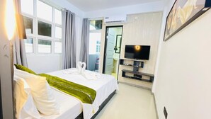A hotel room with a bed, a TV, and a window with curtains. - Dream Relax (Hulhumalé)