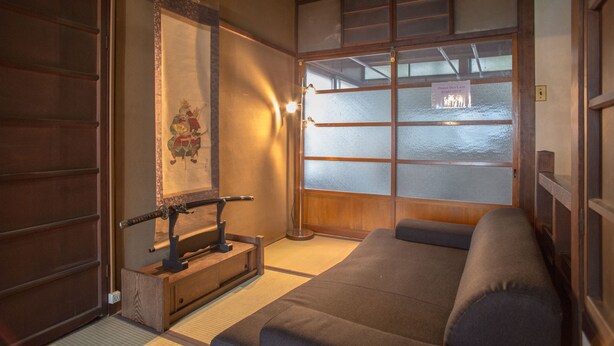 A traditional Japanese room with tatami flooring, a low wooden bed, a shoji screen, and a sliding door. - KYOMACHIYA NO YADO 794inn KIYOMIZUGOJO (Kyoto)