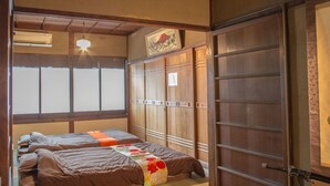 A traditional Japanese-style room with tatami flooring, a low wooden ceiling, and a sliding door. - KYOMACHIYA NO YADO 794inn KIYOMIZUGOJO (Kyoto)