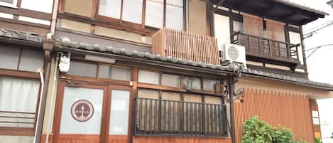 A traditional Japanese building with a wooden facade, large windows, and a balcony.